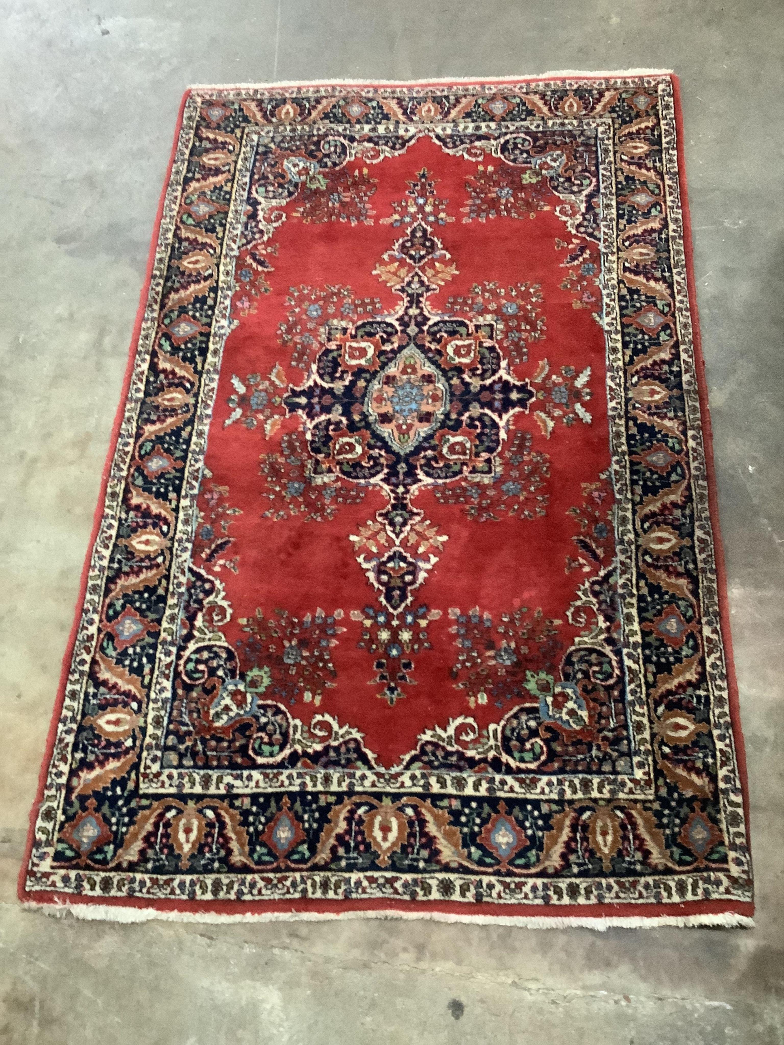 A Persian red ground floral medallion rug, 190 x 115cm. Condition - fair